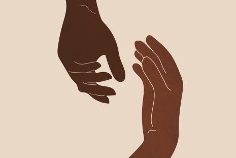 hands with two different brown skin tones reaching toward each other